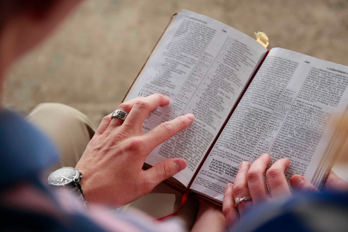 A reader holding an open Bible during a devotional reading.